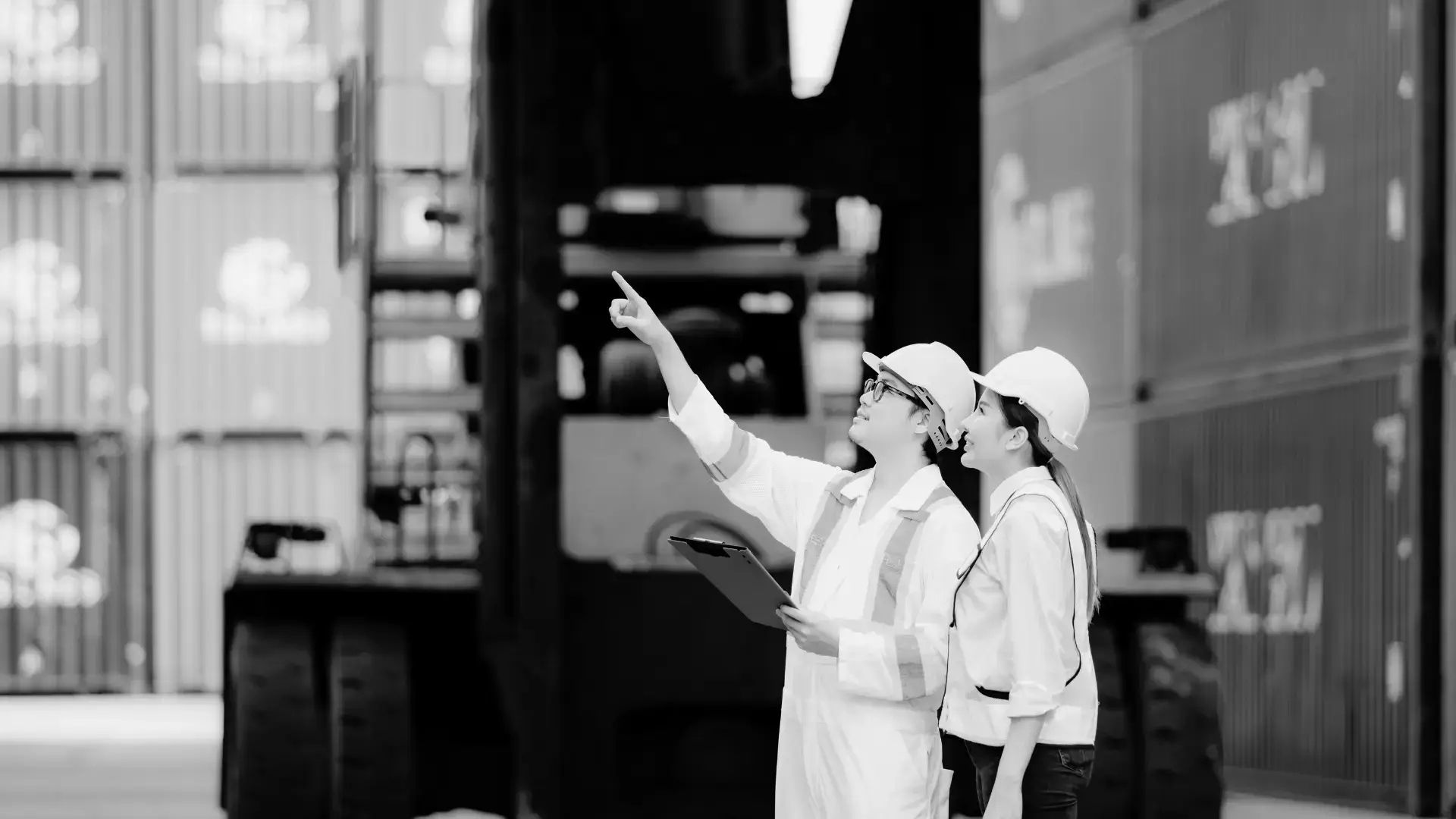 Warehouse workers in safety gear using digital tablet for order management
