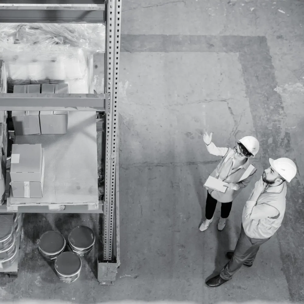 Warehouse staff using handheld scanner to check large wrapped cargo and pallets