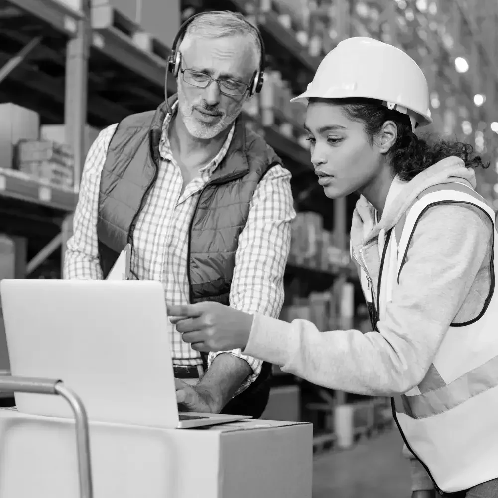 Warehouse supervisors reviewing data together on a computer screen