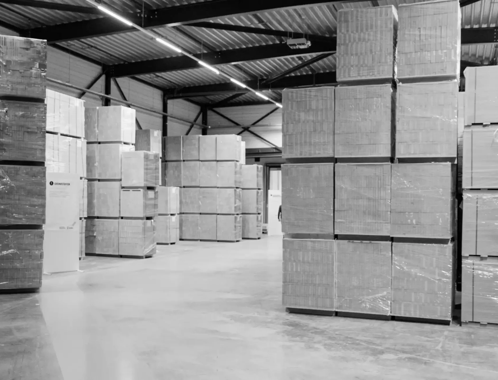 Tall stacks of pallets stored in a large 3PL warehouse facility